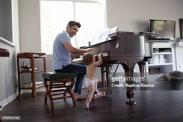 father and baby boy playing on piano - santa clarita stock pictures, royalty-free photos & images