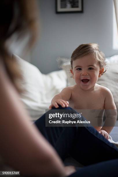 baby boy holding mothers leg looking at camera smiling - santa clarita stock pictures, royalty-free photos & images