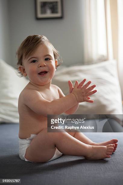 baby boy wearing nappy clapping hands, looking at camera smiling - santa clarita stock pictures, royalty-free photos & images