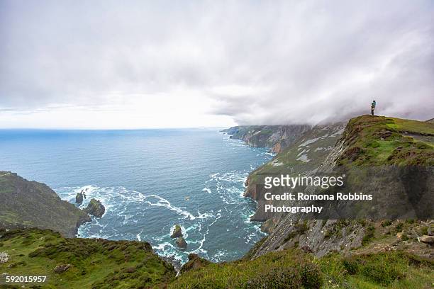 daughter sitting on fathers shoulders looking at view from cliff, slieve league, county donegal, ireland - slieve league donegal stock pictures, royalty-free photos & images