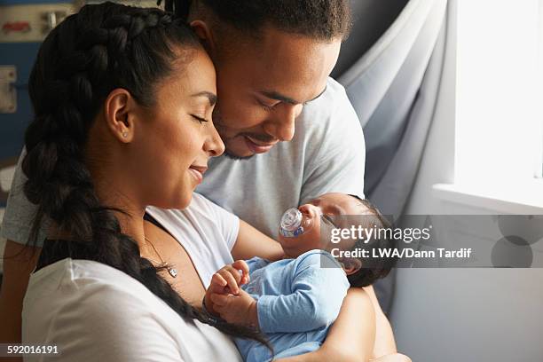 couple cradling newborn baby - mum dad and baby fotografías e imágenes de stock