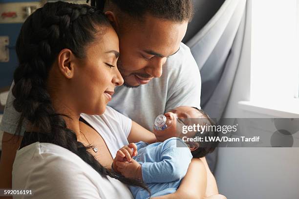 couple cradling newborn baby - newborn stock pictures, royalty-free photos & images
