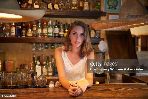 bartender leaning on bar in restaurant - bar girl stock-fotos und bilder