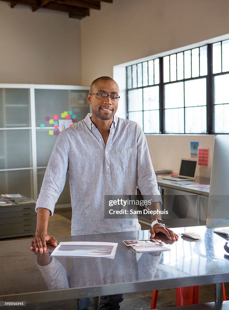 Mixed race businessman smiling at desk in office