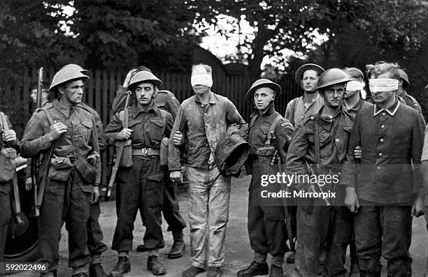 German prisoners taken in the Dieppe Raid of August 19, 1942 are blindfolded and escorted through the streets after the return of the commandos to...