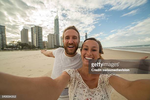 caucasian couple take a selfie portrait at surfer's paradise beach - surfers paradise stock pictures, royalty-free photos & images