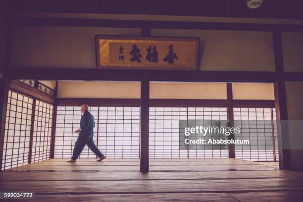 senior caucasian man exercising karate in buddhist temple, kyoto, japan - senior spirituality stock pictures, royalty-free photos & images