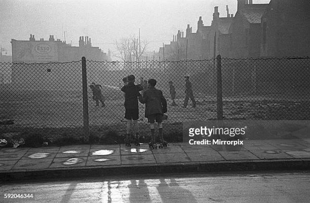 Life in the Mirror Our Gang. 19th January 1954 Boys playing football watched on by others on a bomb site off Bow Road in the East End of London