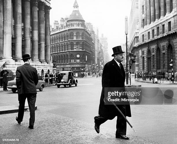 City types walk at Mansion House, umbrellas in hand. 23rd January 1959.