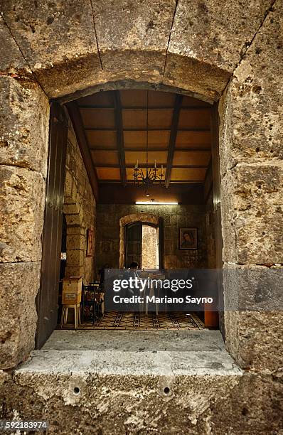 a guardian sitting on his workplace inside a chapel of fort santiago - fort santiago manila stock pictures, royalty-free photos & images