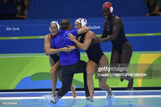 S team jump with their coach Adam Krikorian in the pool after winning the women's water polo final between Italy and USA at the Rio 2016 Olympic...