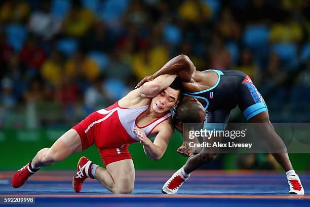 Kyong Il Yang of North Korea competes against Yowlys Bonne Rodriguez of Cuba during the Men's 57kg Repechage Wrestling match on Day 14 of the Rio...