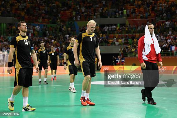 Martin Strobel, Patrick Wiencek and Silvio Heinevetter of Germany look dejected after loosing the Men's Handball Semifinal match between France and...