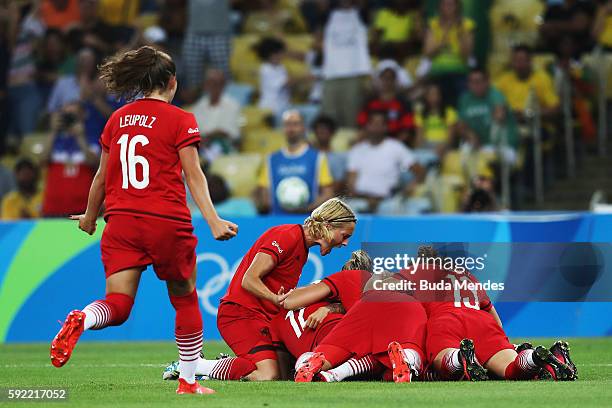 Dzsenifer Marozsan of Germany is congratulated by team mates after scoring during the Women's Olympic Gold Medal match between Sweden and Germany at...