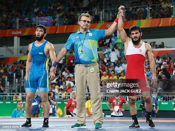 Turkey's Soner Demirtas is declared winner at the end of his men's 74kg freestyle bronze medal match against Kazakhstan's Galymzhan Usserbayev on...