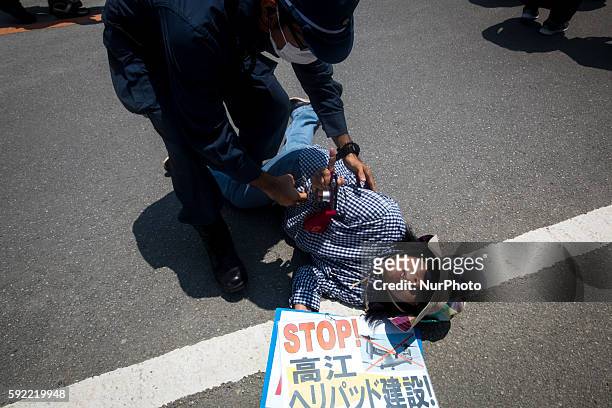 Anti U.S base protesters is seen being removed by police after they staged a sit-in protest protest against the construction of helipads in front of...
