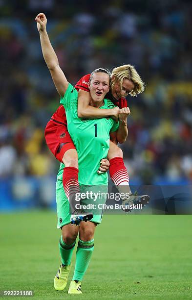 Almuth Schult of Germany and Saskia Bartusiak of Germany celebrate victory in the Women's Olympic Gold Medal match between Sweden and Germany at...