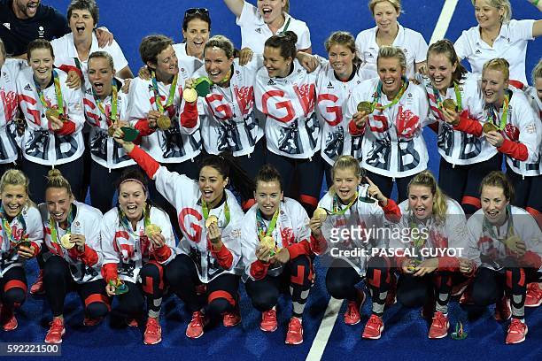 Britain's gold medallists celebrate on the podium during the women's field hockey medals ceremony of the Rio 2016 Olympics Games at the Olympic...