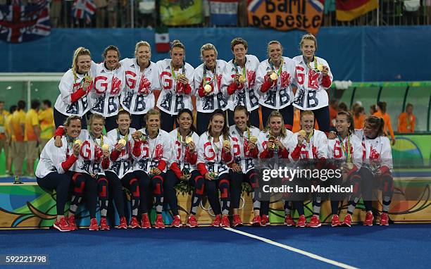 Great Britain pose on the podium after winning a penalty shoot out during the Women's Hockey final between Great Britain and the Netherlands on day...