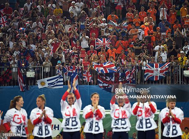 Britain's gold medallists celebrate during the women's field hockey medals ceremony of the Rio 2016 Olympics Games at the Olympic Hockey Centre in...