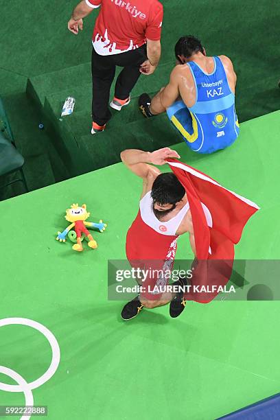 An overview shows Turkey's Soner Demirtas celebrating after winning against Kazakhstan's Galymzhan Usserbayev in their men's 74kg freestyle bronze...