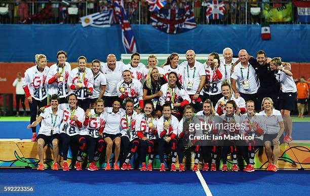 Great Britain pose on the podium after winning a penalty shoot out during the Women's Hockey final between Great Britain and the Netherlands on day...