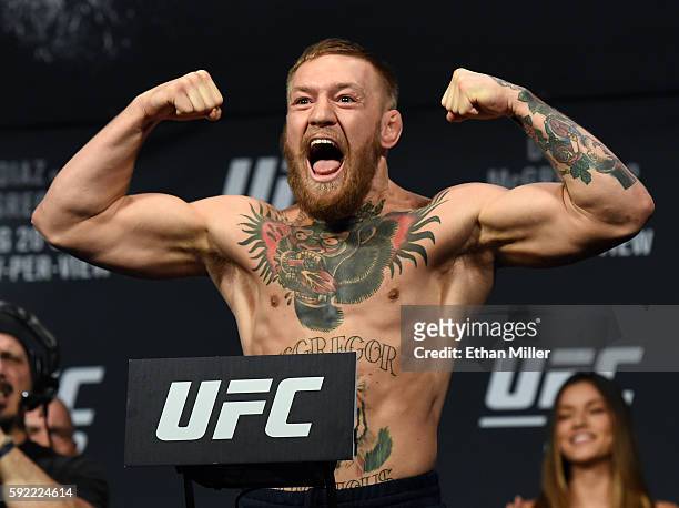 Featherweight champion Conor McGregor poses on the scale during his weigh-in for UFC 202 at MGM Grand Conference Center on August 19, 2016 in Las...