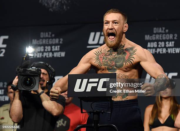 Featherweight champion Conor McGregor poses on the scale during his weigh-in for UFC 202 at MGM Grand Conference Center on August 19, 2016 in Las...