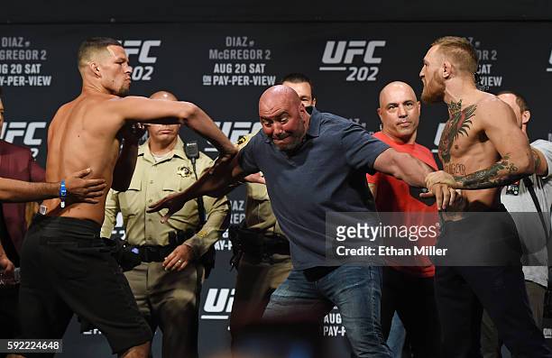 President Dana White separates mixed martial artist Nate Diaz and UFC featherweight champion Conor McGregor as they face off during their weigh-in...
