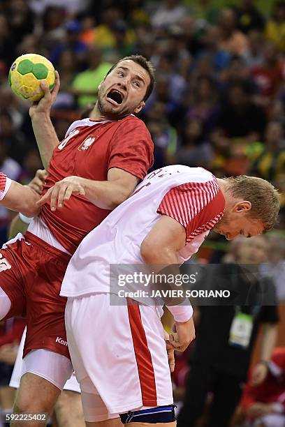 Poland's left back Mariusz Jurkiewicz vies with Denmark's pivot Rene Toft Hansen and Denmark's left back Mikkel Hansen during the men's semifinal...