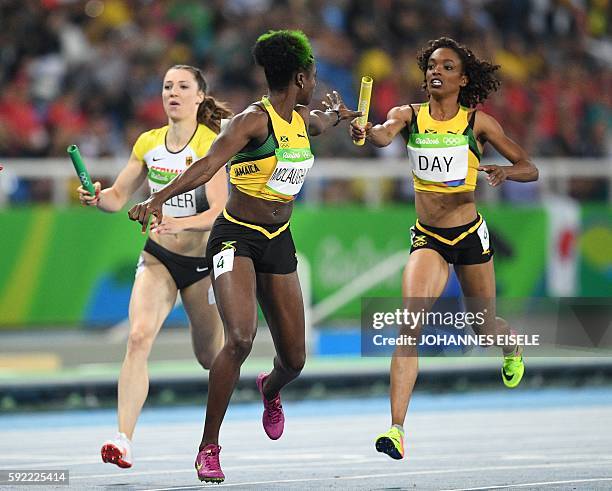 Jamaica's Anneisha Mclaughlin-Whilby receives the baton from Jamaica's Christine Day during the Women's 4x400m Relay Round 1 during the athletics...