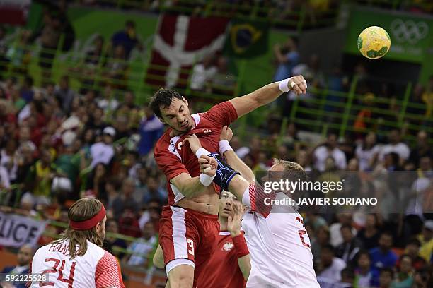 Poland's right back Krzysztof Lijewski shoots past Denmark's pivot Rene Toft Hansen during the men's semifinal handball match Poland vs Denmark for...