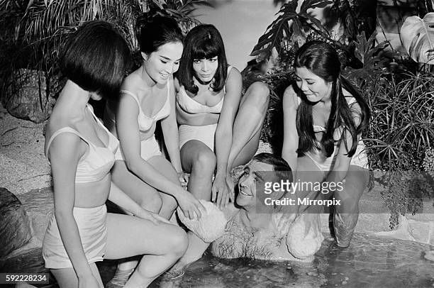 Sean Connery in his roles as James Bond being washed by a group of ladies in a scene from the film You Only Live Twice during filming at Pinewood...