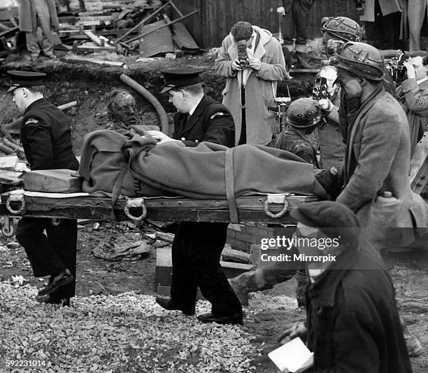 Rescue workers taking away bodies on stretchers. March 1962 P017891