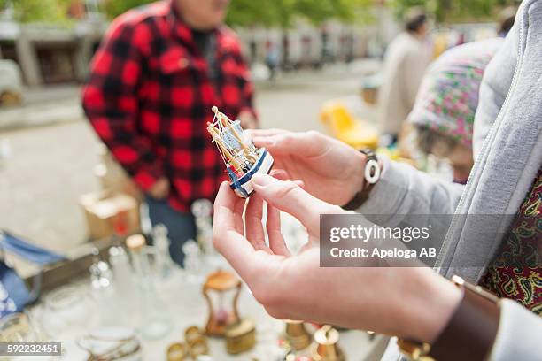 cropped image of man holding antique ship toy at flea market - flea market stockfoto's en -beelden