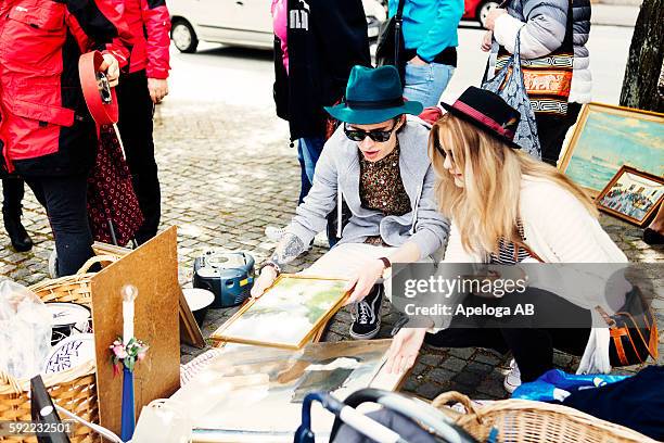 friends choosing picture frames at flea market - skane stock pictures, royalty-free photos & images
