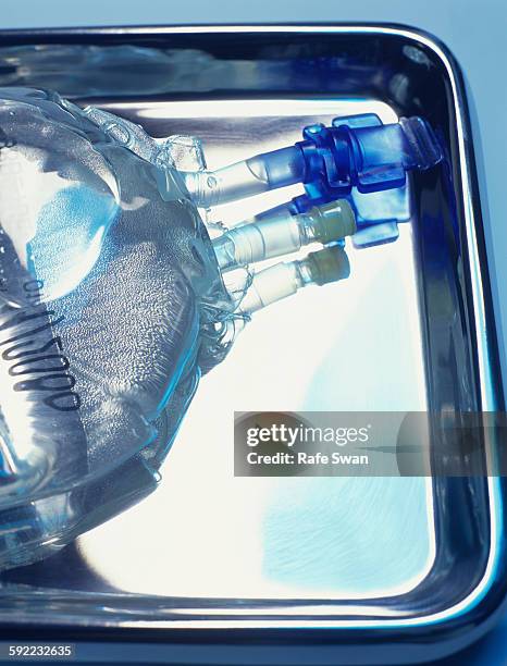 sealed intravenous drip bag on a surgical tray - surgical tray stock pictures, royalty-free photos & images