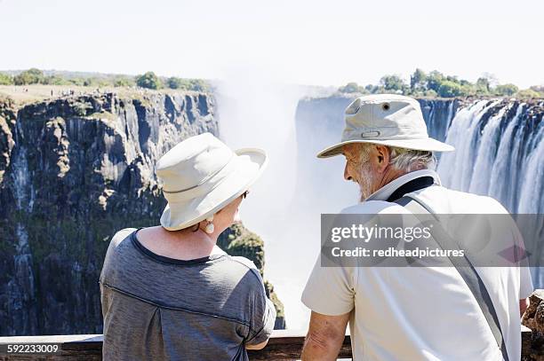 couple looking out to victoria falls, zambia - victoria falls stock pictures, royalty-free photos & images