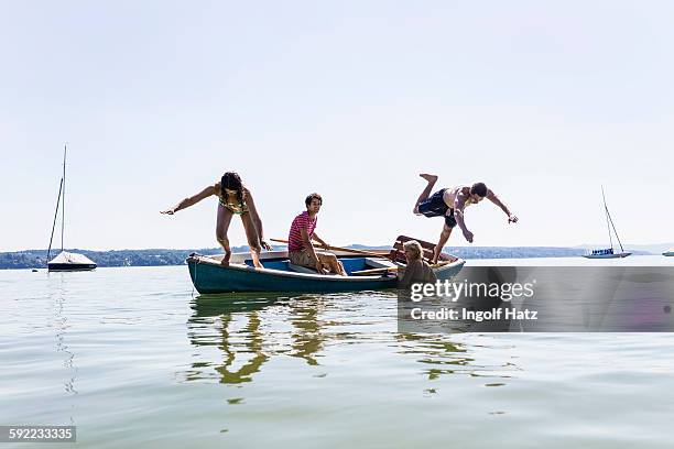 group of friends diving from boat into lake, schondorf, ammersee, bavaria, germany - ammersee stockfoto's en -beelden