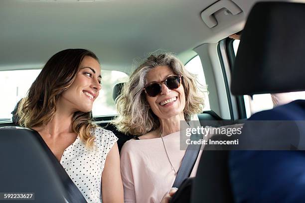 two women chatting in back seat of car - daughter car stock pictures, royalty-free photos & images