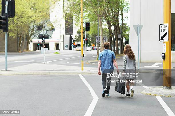 young couple carrying bag together on street, melbourne, victoria, australia - melbourne school stock pictures, royalty-free photos & images