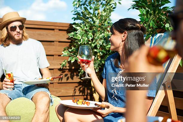 friends talking and drinking at rooftop party - party food and drink stock pictures, royalty-free photos & images