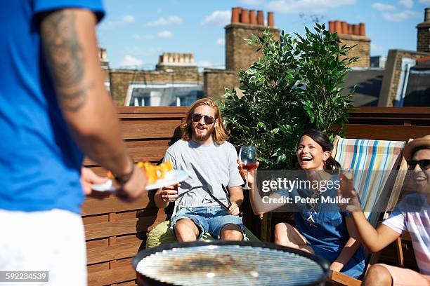 adult friends raising a toast at rooftop party - asian person bbq stock-fotos und bilder