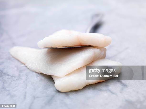 high angle view of pile of raw icelandic cod fish on marble - kabeljau stock-fotos und bilder