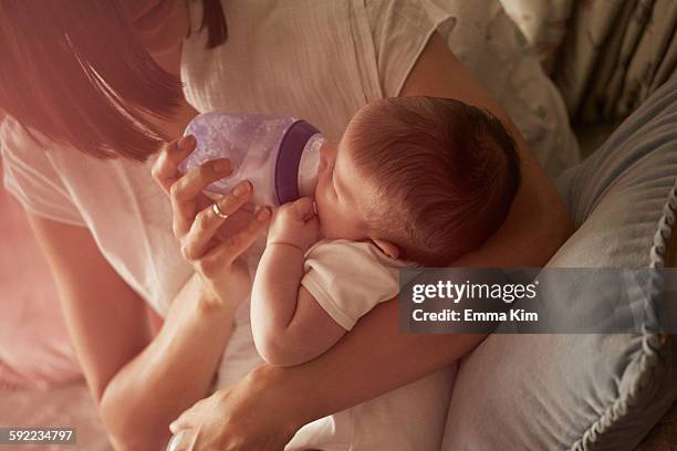 mother feeding baby in arms - adult eating no face stock pictures, royalty-free photos & images