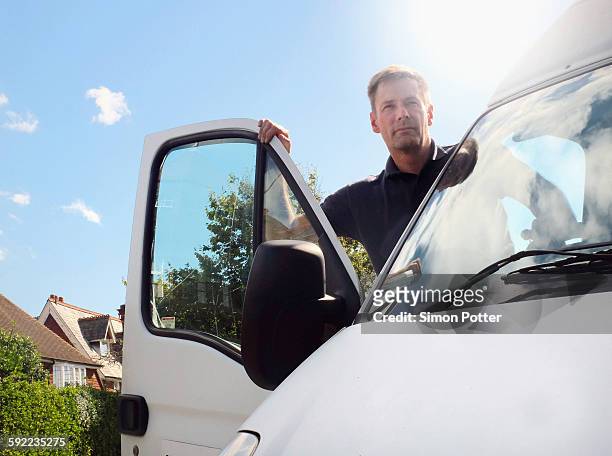 delivery man looking out from white van on suburban street - minivan ストックフォトと画像