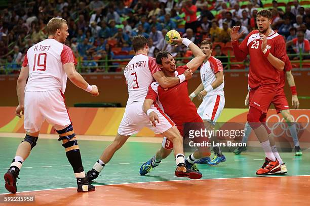 Krzysztof Lijewski of Poland gets blocked by Mads Christiansen of Denmark during the Men's Handball Semifinal match between Poland and Denmark on Day...