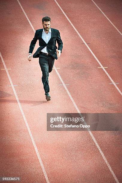 high angle view of mid adult man running on racetrack - in due course stock pictures, royalty-free photos & images