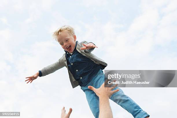 father throwing son mid air - dad throwing kid in air stockfoto's en -beelden