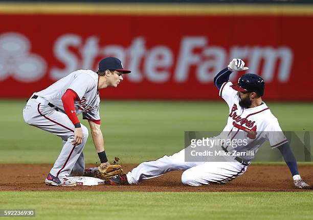 Right fielder Nick Markakis of the Atlanta Braves is tagged out during a stolen base attempt by second baseman Trea Turner of the Washington...